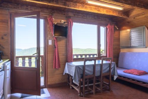 a dining room with a table and a balcony at Chalet les moraines 8 in Le Tholy