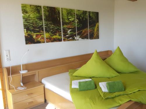 a bedroom with a bed with green pillows at Fischerhof in Höchenschwand