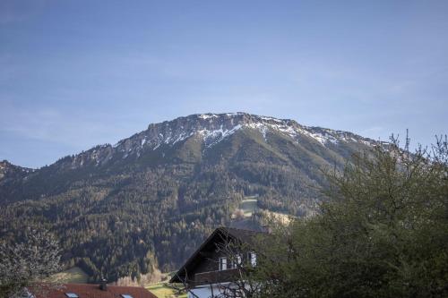 a snow covered mountain with a house in front of it at Haus Bergliebe in Pfronten