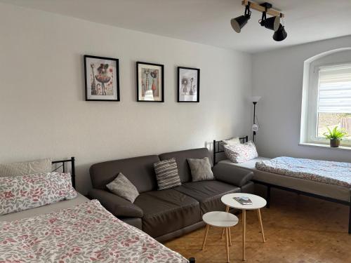 ein Wohnzimmer mit einer Couch und zwei Betten in der Unterkunft Wohnung Weida in Riesa