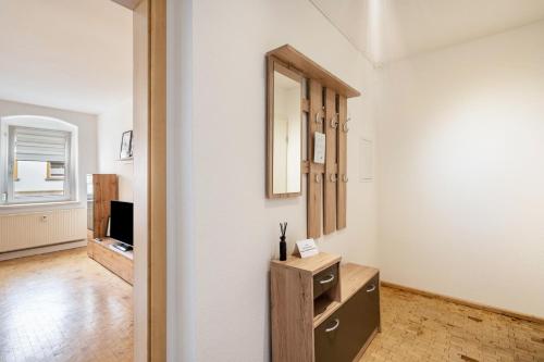 ein Zimmer mit einer Kommode und einem Spiegel an der Wand in der Unterkunft Wohnung Weida in Riesa