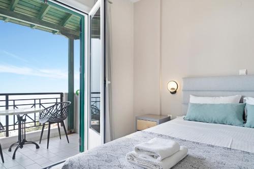 a bedroom with a bed and a balcony at Sunset Premium Studio 7 in Lefkada
