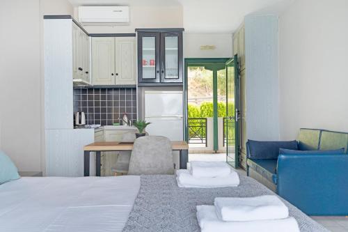 a bedroom with a bed and a table and a kitchen at Sunset Premium Studio 7 in Lefkada