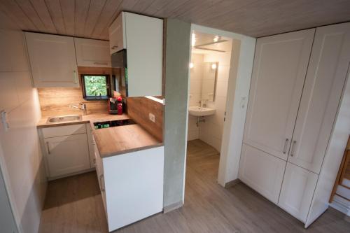 a kitchen with white cabinets and a sink at Blockhaus Quellental in Odderade
