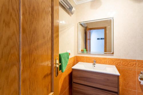 a bathroom with a sink and a wooden door at Almdna15-atc in Torrevieja