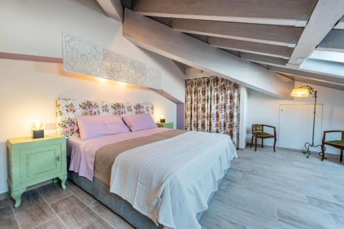 a bedroom with a large bed with pink pillows at Abaye 5 Barolo - Charm Adults Only in Soiano del Lago