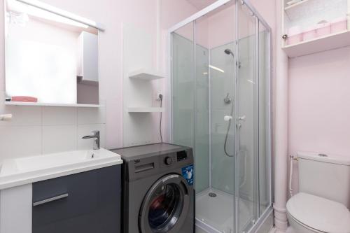 a bathroom with a washing machine and a shower at Location Seignosse Le Penon in Seignosse