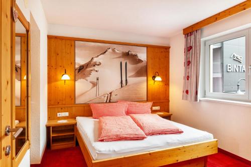 a bedroom with a bed with a painting on the wall at Alpenflora 1 in Ischgl