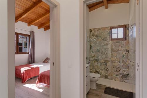 a bedroom with a bed and a bathroom with a shower at Los Barranquillos in Las Palmas de Gran Canaria