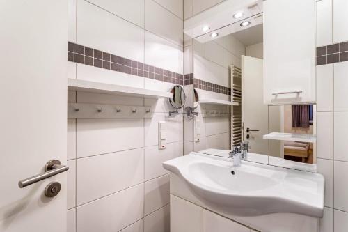 a white bathroom with a sink and a mirror at Ferienwohnung Viadukt in Willingen