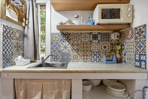 a kitchen with a sink and a microwave at La Posada de la Pinaleta in Chiclana de la Frontera