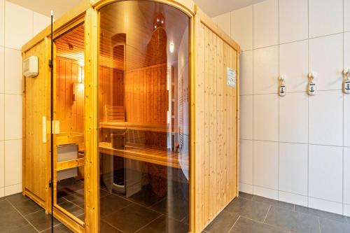 a dressing room with wooden cabinets and tiled walls at Ferienvilla Kapitänshaus in Karlshagen