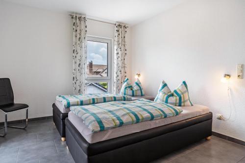 a bedroom with two beds and a window at Ferienvilla Kapitänshaus in Karlshagen
