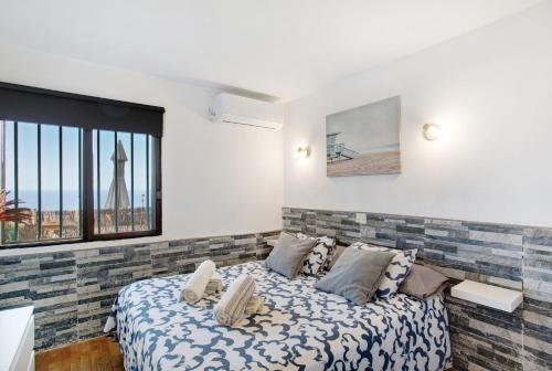 a bedroom with a bed and a large window at Sunset Apartment in Puerto Rico de Gran Canaria