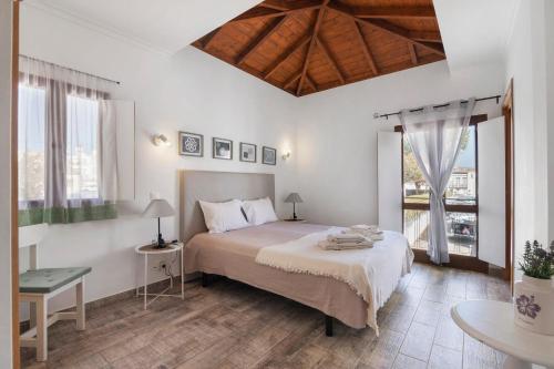 a bedroom with a bed and a table and windows at Casa Do Alto in Tavira