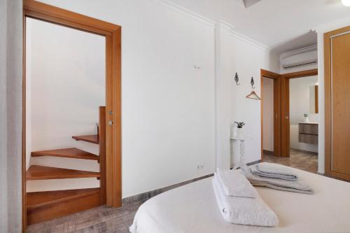 a bedroom with a white bed and a staircase at Casa Do Alto in Tavira