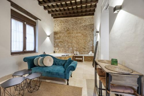 a living room with a blue couch and a tub at Bella Encantada in Cádiz