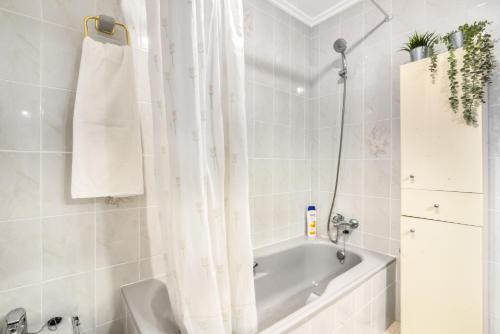 a bathroom with a bath tub with a shower curtain at Cal Guerrer in Mogente