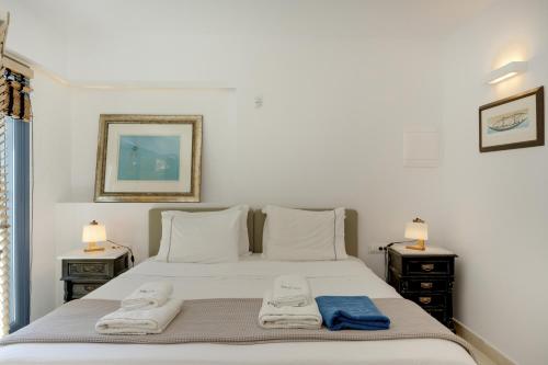 a bedroom with a large white bed with towels on it at Blueros - Olive suite in Megas Gialos - Nites