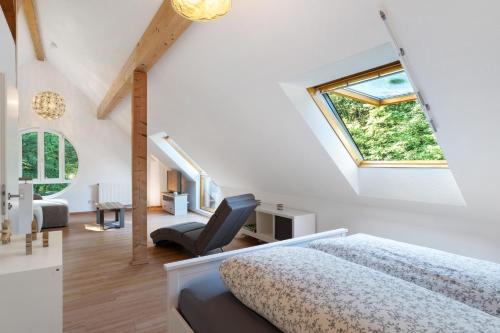 a attic bedroom with a bed and a chair at Ferienwohnung am Hirschfelsen in Bühlertal