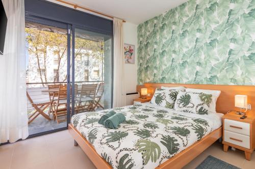 a bedroom with a bed and a balcony with a table at Mar i Llum in Platja d'Aro