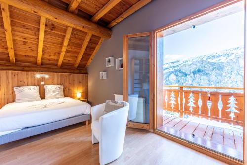 a bedroom with a bed and a large window at Chalet au bois joli in Valloire