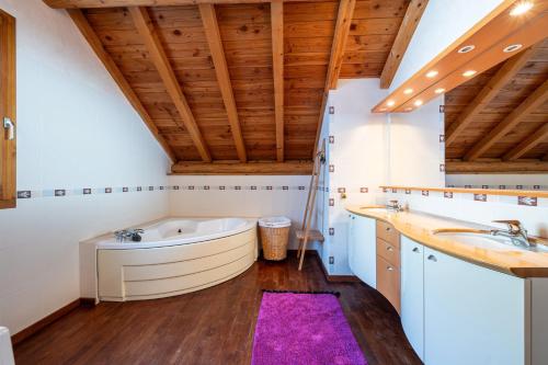 a bathroom with a tub and a sink at Chalet au bois joli in Valloire