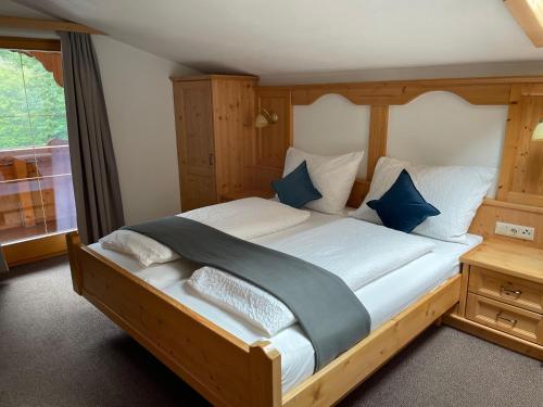 a bedroom with a large wooden bed with blue pillows at Apartment Bergglück Wildschönau in Wildschönau