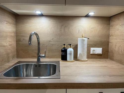 a kitchen counter with a sink and two bottles of wine at Apartment Bergglück Wildschönau in Wildschönau