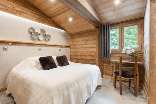 a bedroom with a bed and a desk and a window at Chalet Karavi in Manigod