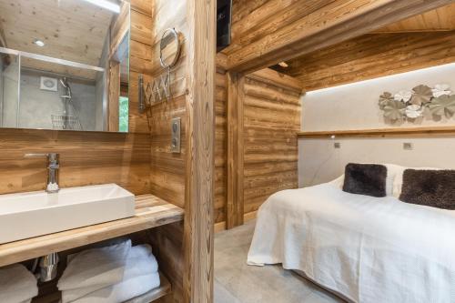 a bathroom with a sink and a bed at Chalet Karavi in Manigod