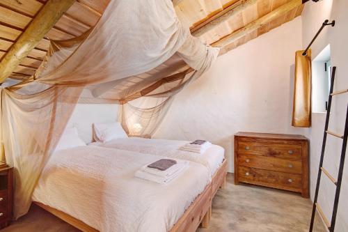 a bedroom with a canopy bed and a wooden dresser at Casa Osga in Moncarapacho