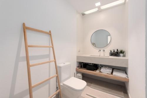 a bathroom with a white toilet and a mirror at Vivienda Casares in Estepona