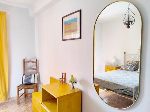 a mirror in a bedroom with a bed and a chair at Casa Lagoa Mar in Costa de Santo André