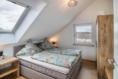 a bedroom with a bed and two windows at Blick zum Säntis in Horgenzell