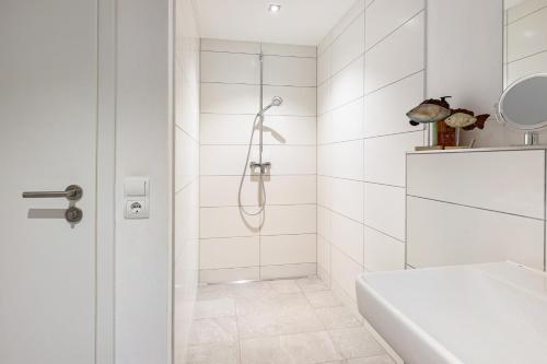 a white bathroom with a shower and a sink at Schmuckstückchen in Hilzingen