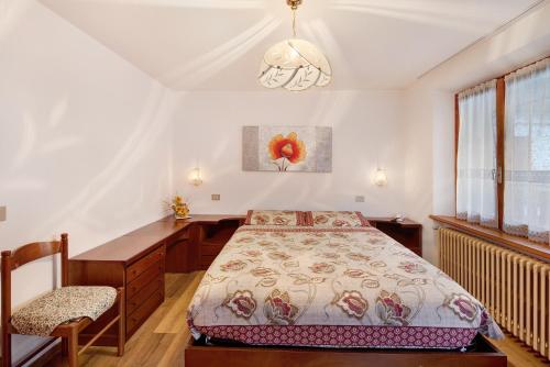 a bedroom with a bed and a desk at A Due Passi Valdidentro in Valdidentro