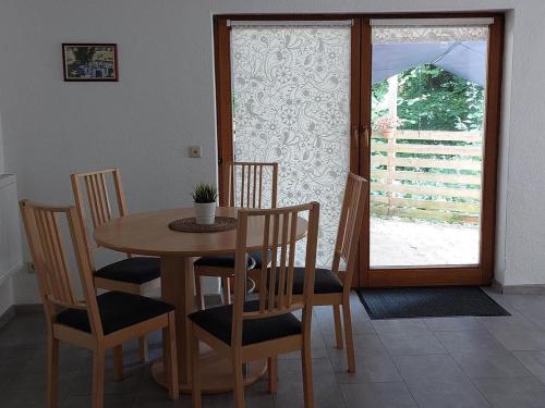 a dining room with a table and chairs and a window at Ferienwohnung, offenes Apartment in Mochenwangen