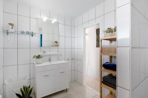 a white bathroom with a sink and a mirror at La Chinija in Playa Honda