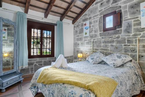 a bedroom with a stone wall and a bed at Casas Alfonso y Laura in Conil de la Frontera