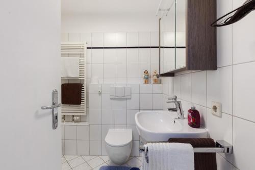 a white bathroom with a sink and a toilet at Schweizer Grenze in Waldshut-Tiengen