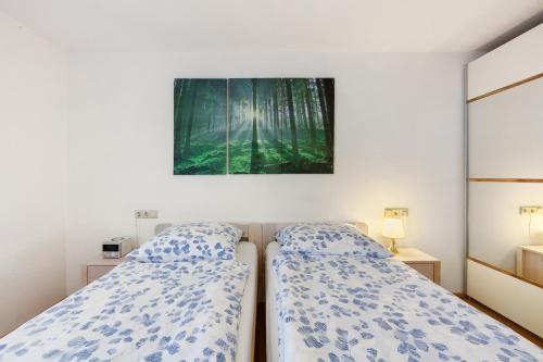 two beds in a bedroom with a painting on the wall at Schweizer Grenze in Waldshut-Tiengen