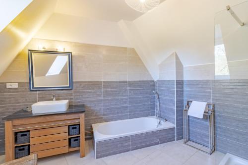 a bathroom with a sink and a bath tub at Le Promontoire in Groléjac