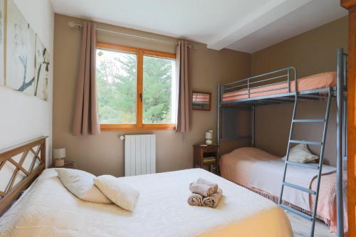a bedroom with two bunk beds and a window at L'Annexe du Petit Echo de la mode in Plélo