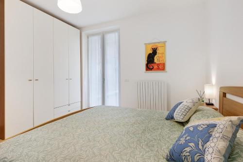 a white bedroom with a bed and a window at Condo-Micio Luna in Villafranca di Verona