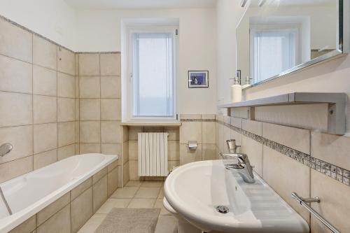 a bathroom with a tub and a sink and a bath tub at Condo-Micio Luna in Villafranca di Verona