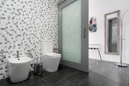 a white bathroom with a toilet and a sink at 58 Studio in Ribeira Grande