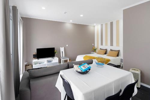 a living room with a white table and a couch at 58 Studio in Ribeira Grande