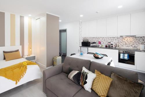 a living room with a couch and a kitchen at 58 Studio in Ribeira Grande