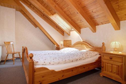 a bedroom with a wooden bed and a chair at Obst- und Ferienhof Lehle in Immenstaad am Bodensee